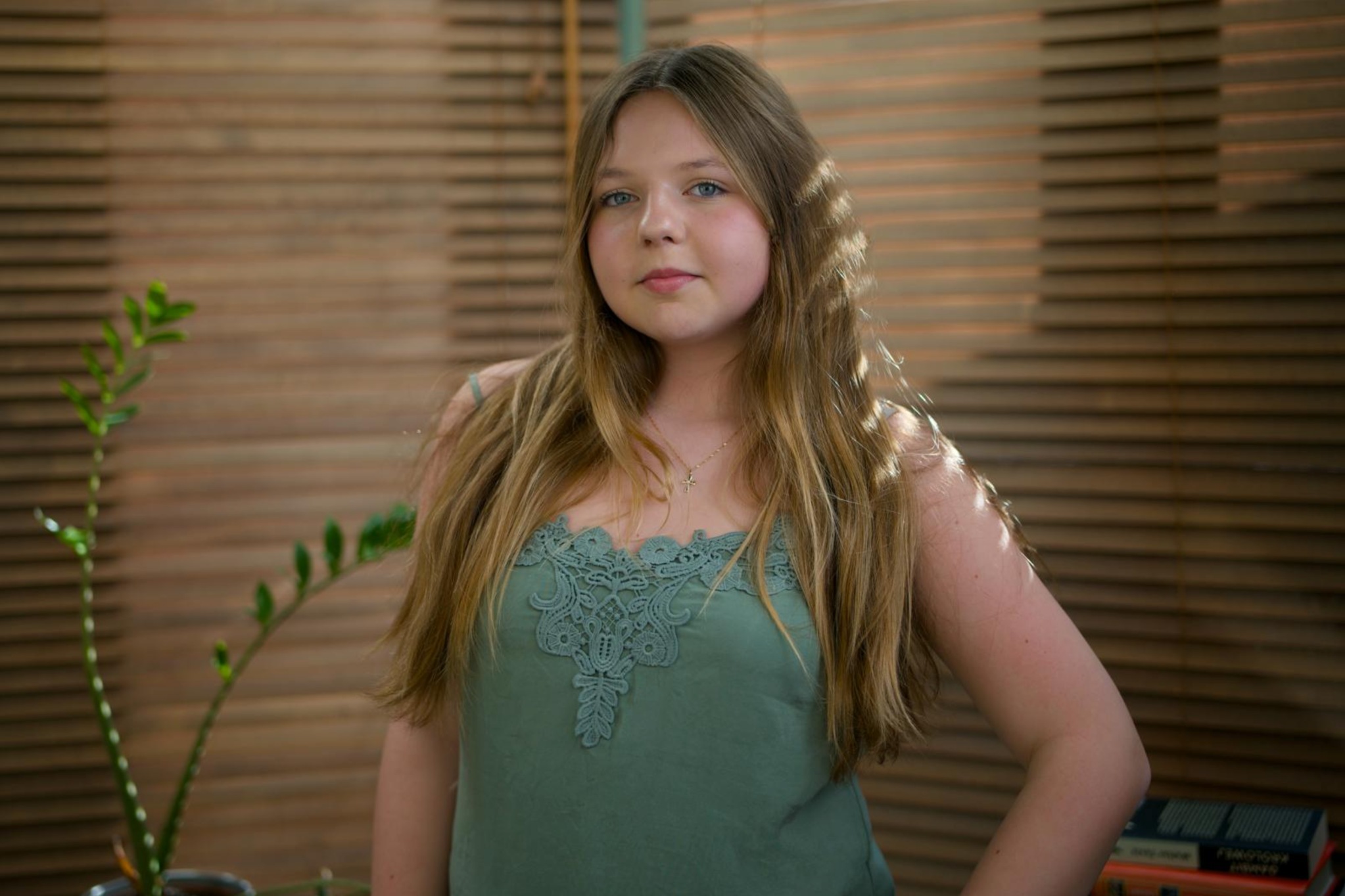 Julia Herman in a sage green top, looking towards the camera.